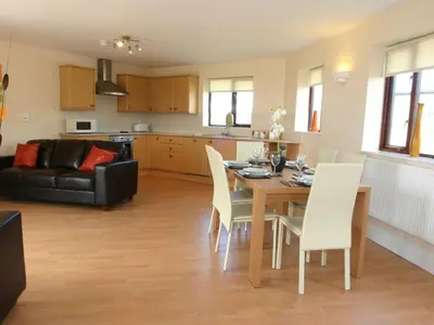 a kitchen and living room with a table and chairs at Sea Shore in Marazion