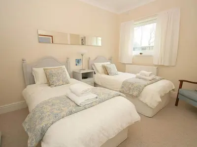 a bedroom with two beds and a window at Trelaze in Wadebridge