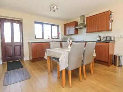 a kitchen with a table and chairs in a room at Seashells in Marazion