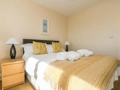 a bedroom with a bed with towels on it at Seashells in Marazion