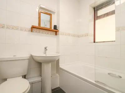 a bathroom with a sink and a toilet and a bath tub at Seashells in Marazion