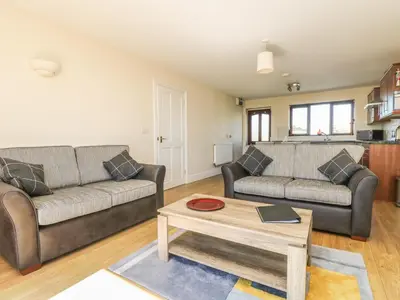 a living room with two couches and a coffee table at Seashells in Marazion