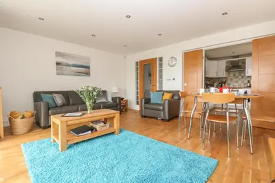 a living room with a couch and a table at Rock Pool in Downderry