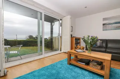 a living room with a couch and a table at Rock Pool in Downderry