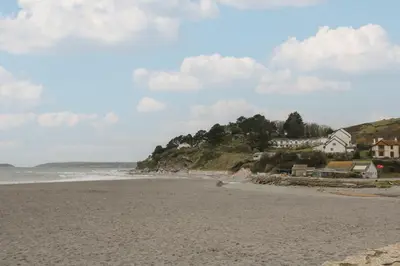 a sandy beach with houses and the ocean at Rock Pool in Downderry