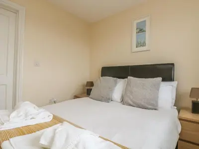 a bedroom with a large bed with white sheets and pillows at Shoreline in Marazion