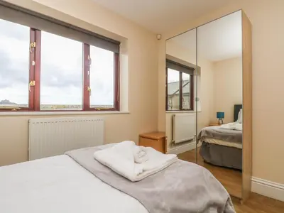 a bedroom with a bed and a mirror at Shoreline in Marazion