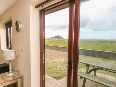 a sliding glass door with a view of a picnic table at Shoreline in Marazion