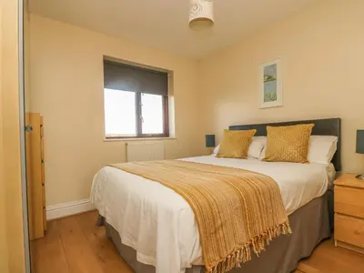 a bedroom with a large bed and a window at Seabreeze in Marazion