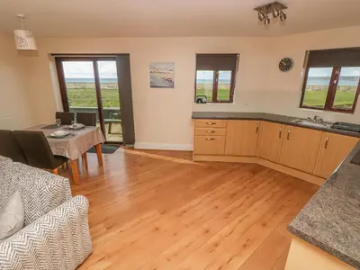 a living room with a kitchen and a table at Seabreeze in Marazion