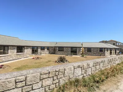 a stone retaining wall in front of a building at Seabreeze in Marazion