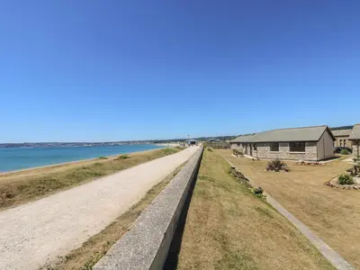 a road leading down to the beach with a house at Sail Boats in Marazion