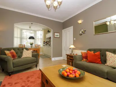a living room with two couches and a bowl of fruit on a table at Mount View in Marazion