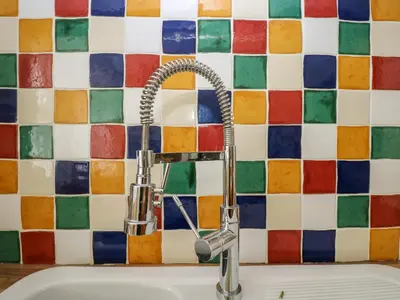 a kitchen sink with a faucet and a tile wall at Mount View in Marazion