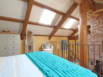 a bedroom with a large bed and a window at Summer House in Helston