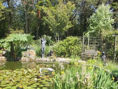 a garden with a statue in the middle of a pond at Summer House in Helston