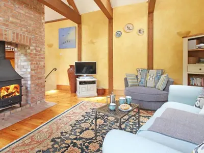 a living room with a couch and a fireplace at Summer House in Helston