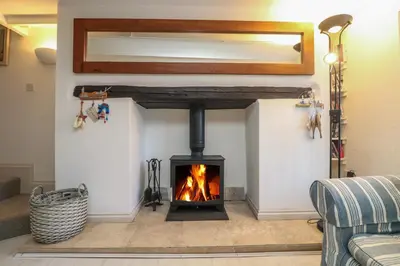 a fireplace in a living room with a fire place at Mallards in Pentewan