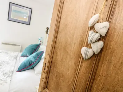 a bedroom with a wooden door with love hearts at Mallards in Pentewan