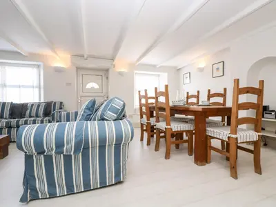 a living room with a dining room table and chairs at Mallards in Pentewan