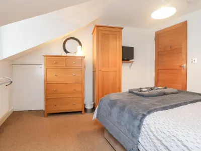 a bedroom with a bed and a dresser at Ebenezer Cottage in Marazion