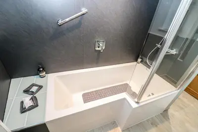 a bathroom with a shower with a white tub at Ebenezer Cottage in Marazion