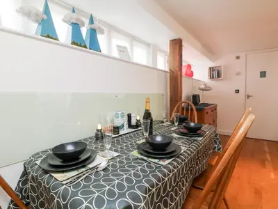 a dining room with a table with a bottle of wine at Ebenezer Cottage in Marazion