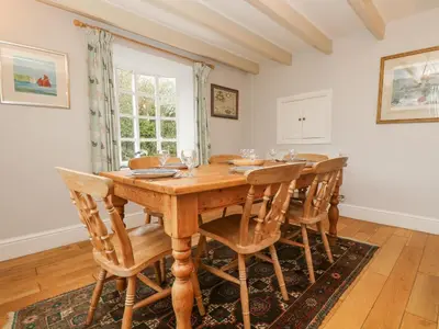 a dining room with a wooden table and chairs at Trenouth Cottage in Padstow