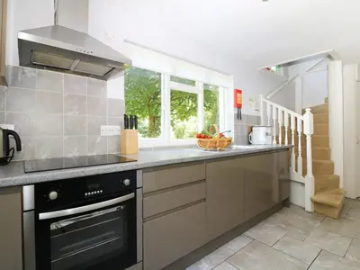 a kitchen with a sink and a stove top oven at Trenouth Cottage in Padstow