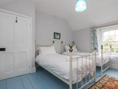 a bedroom with two beds and a window at Trenouth Cottage in Padstow