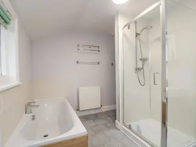 a bathroom with a shower and a tub and a sink at Trenouth Cottage in Padstow