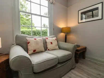 a living room with a couch and a window at Penwarne Lodge in Budock Water