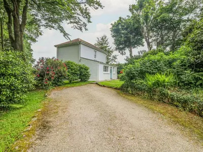 a dirt road in front of a white house at Penwarne Lodge in Budock Water