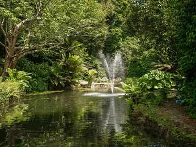 a fountain in the middle of a pond in a park at Penwarne Lodge in Budock Water
