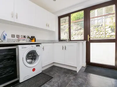 a kitchen with a washer and dryer at Carne Mill in Helston