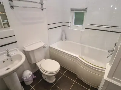 a bathroom with a toilet and a tub and a sink at Banneth in Mawgan