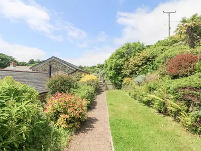 a path leading to a house with flowers at Roosters in Lostwithiel