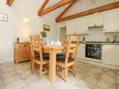a kitchen with a wooden table and chairs at Wagon House in Lostwithiel