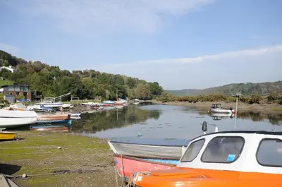 a group of boats sitting on the shore of a river at Wagon House in Lostwithiel