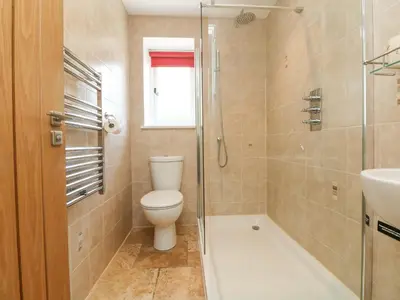a bathroom with a toilet and a shower and a sink at Wagon House in Lostwithiel