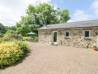 an old stone house with a brick driveway at Wagon House in Lostwithiel