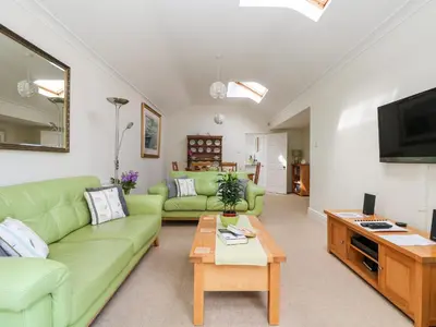 a living room with a green couch and a table at Seabien in Falmouth