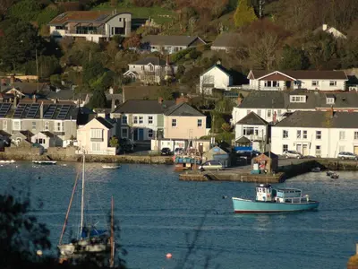a boat in a body of water with houses at Seabien in Falmouth