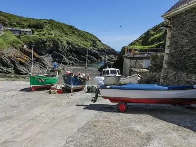 a group of boats are parked on the beach at Kerbenetty Harbour Cottage in Portloe