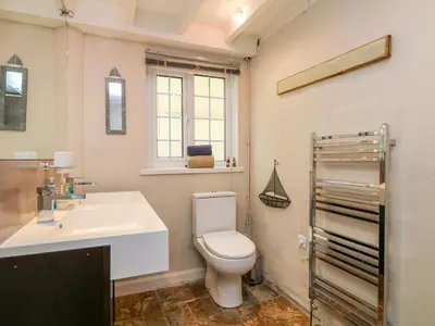 a bathroom with a white toilet and a sink at Parwin in Tintagel