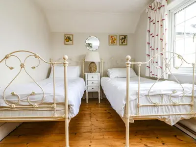 two beds in a bedroom with a window at Parwin in Tintagel