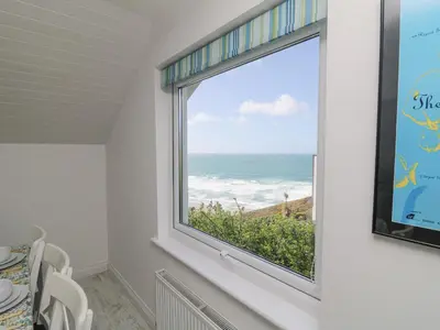 a window in a dining room with a view of the ocean at St Ives View in Porthtowan