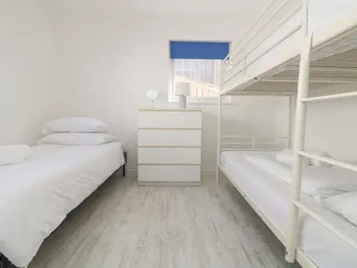 a bedroom with two bunk beds and a desk at St Ives View in Porthtowan