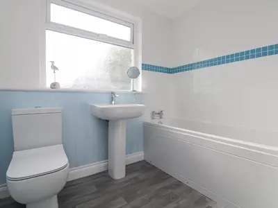 a bathroom with a toilet and a sink and a window at St Ives View in Porthtowan