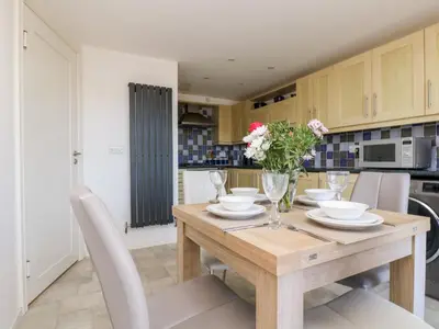 a kitchen and dining room with a wooden table and chairs at Riverview in Lostwithiel